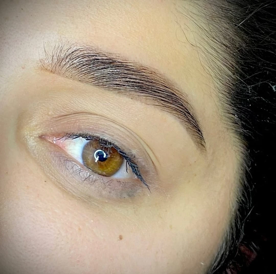 Naturally sculpted eyebrow with brushed-up hairs and open eye