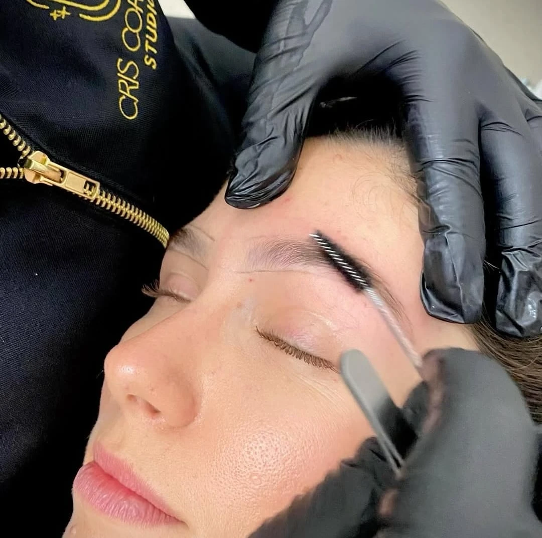 Eyebrow design procedure in progress with spoolie brush