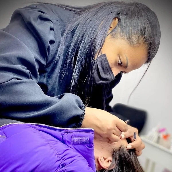 Cris Cordeiro shaping a client's eyebrows at TC Beauty Studio